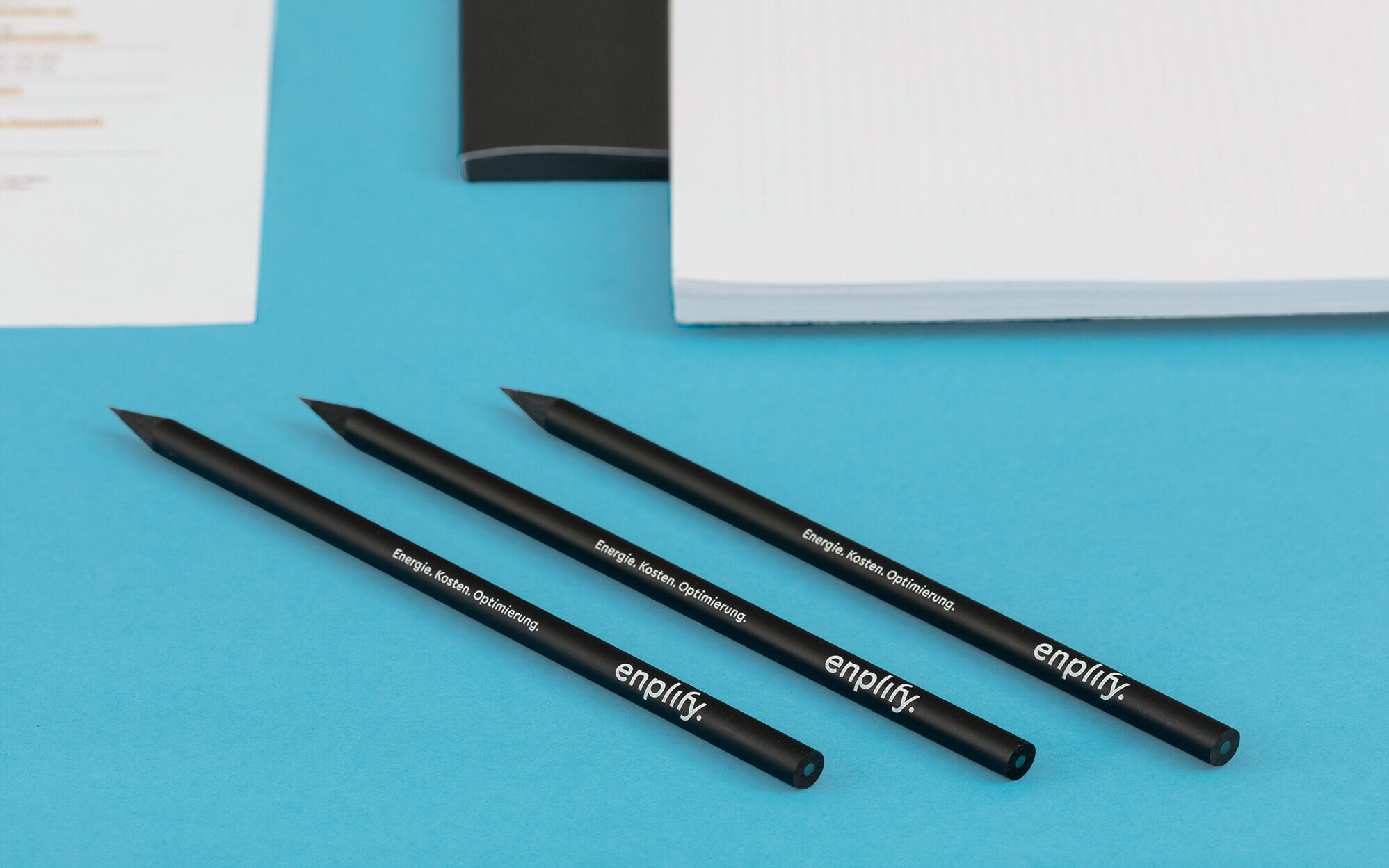 Schwarze Bleistifte mit aufgedrucktem enplify Logo und Slogan