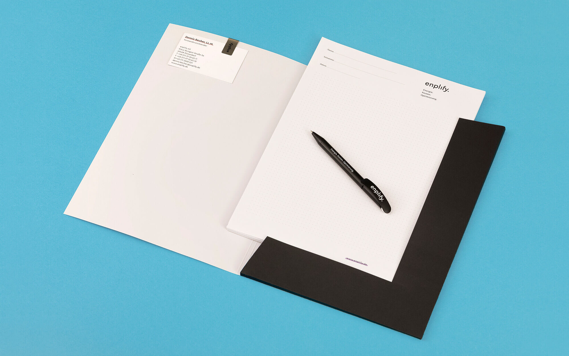 Mappe mit Notizzetteln, Kugelschreiber, Visitenkarte und Briefklammer im enplify Corporate Design